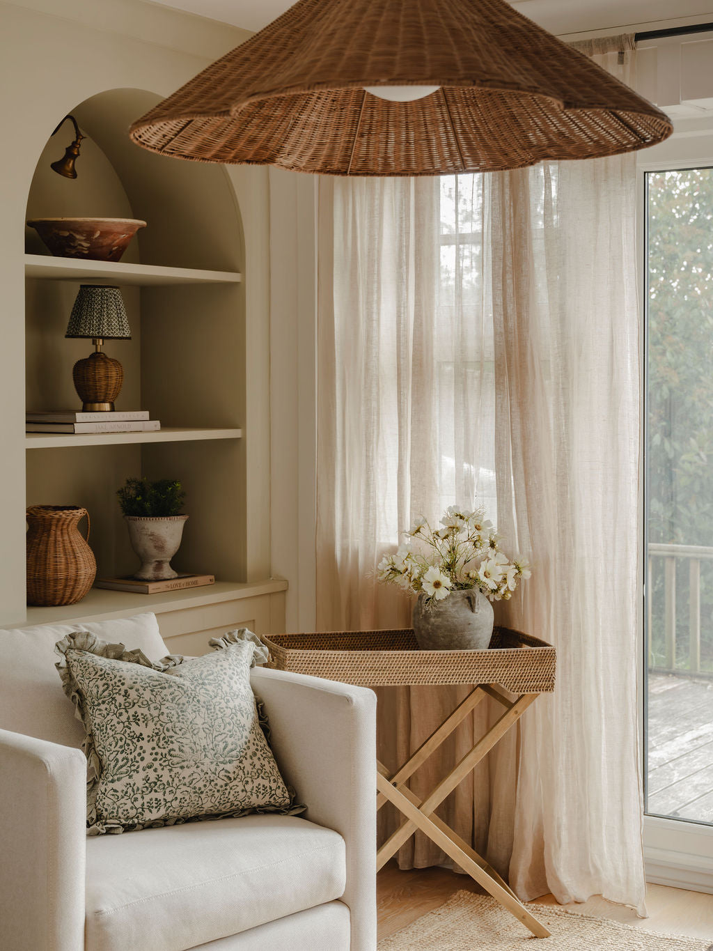 Cozy living room with a wicker lampshade, white sofa, and decorative items.