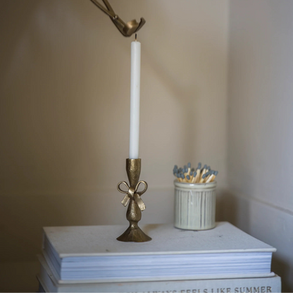 Antique brass bow candle holder with white taper candles
Vintage style brass candle holder gift set in linen bag
Iron candle holder with bow detail and slender white candles
Antique brass candle holder for mantel and table styling
Decorative brass candle holder with rustic patina finish
Classic bow candle holder with six white candles
Elegant antique brass candle holder for home decor
Small brass candle holder styled on a shelf or dining table