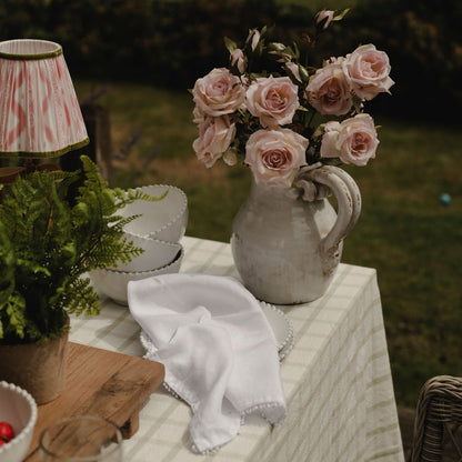 Vase with pink roses on a table outdoors