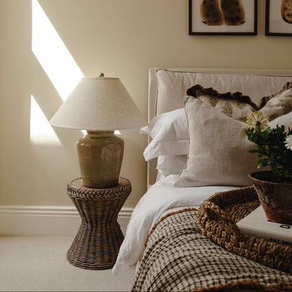 Cozy bedroom with a bed, lamp, and decorative items.