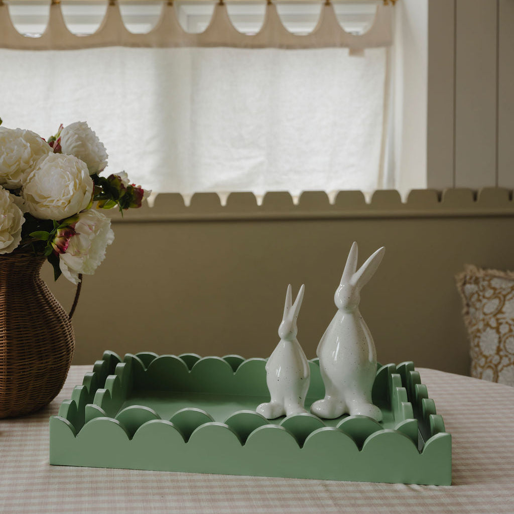 Decorative tray with white rabbit figurines on a table in a home setting.