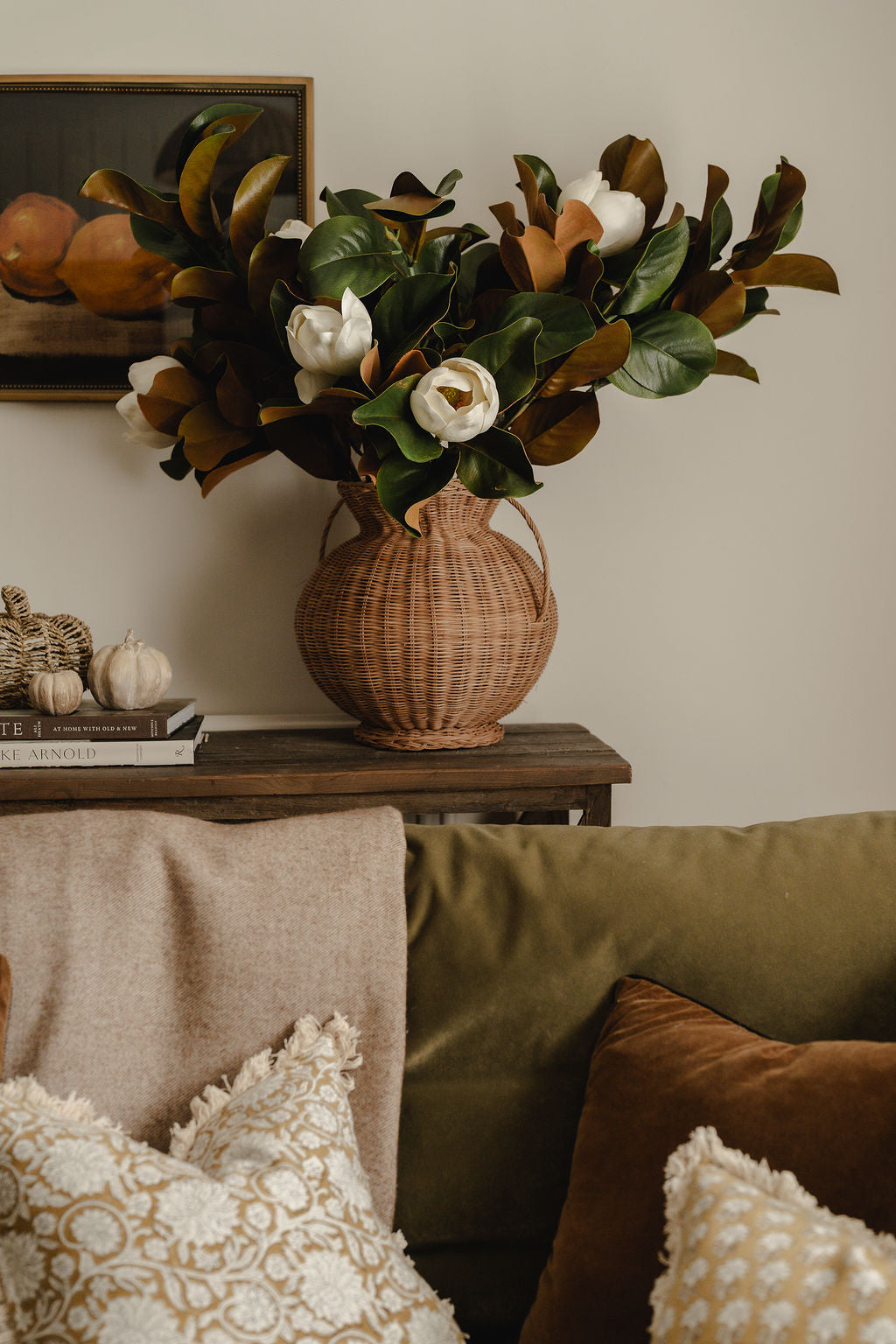 Wicker vase with flowers on a wooden table in a living room setting